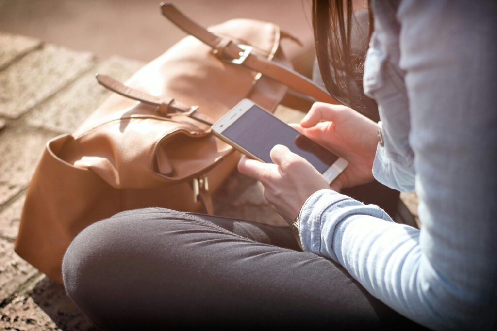 Woman sitting with smartphone in sunlight indicating high level of mobile apps engagement