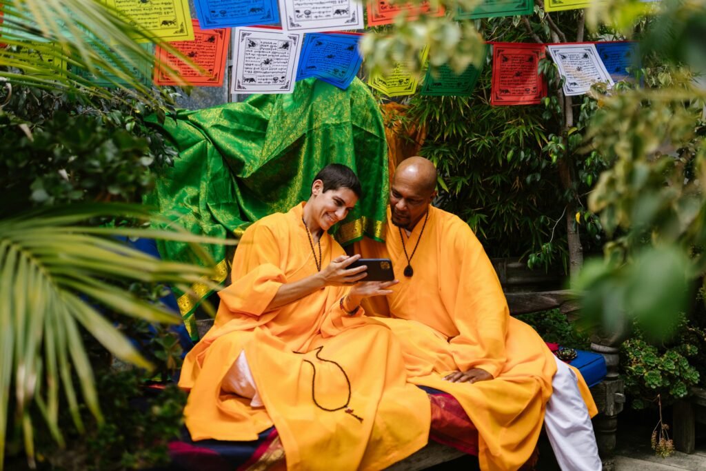 Two monks share a moment with smartphone - digital adoption by people from the hottest sector for investment