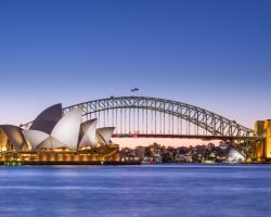 Jørn Utzon's Sydney Opera House, and the Harbour Bridge, two of Sydney's most famous landmarks, taken at dusk. The Sydney Opera House is one of the most iconic buildings built in the 20th century (1973) and is UNESCO's world heritage.-contact